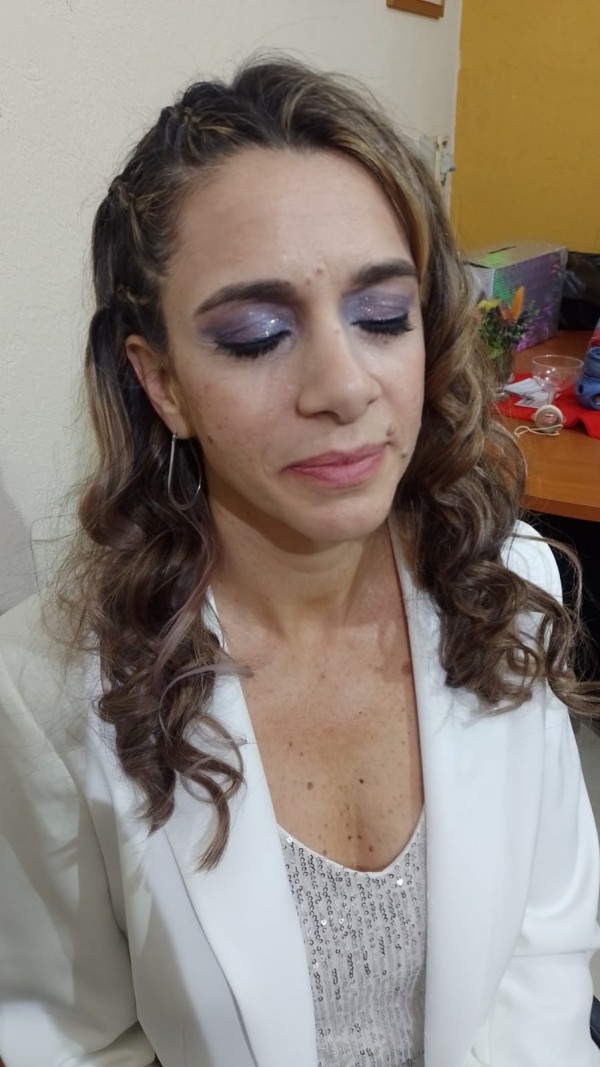 Maquillaje análogo para anfitriona en tonos azules, lilas y rosados con glitter